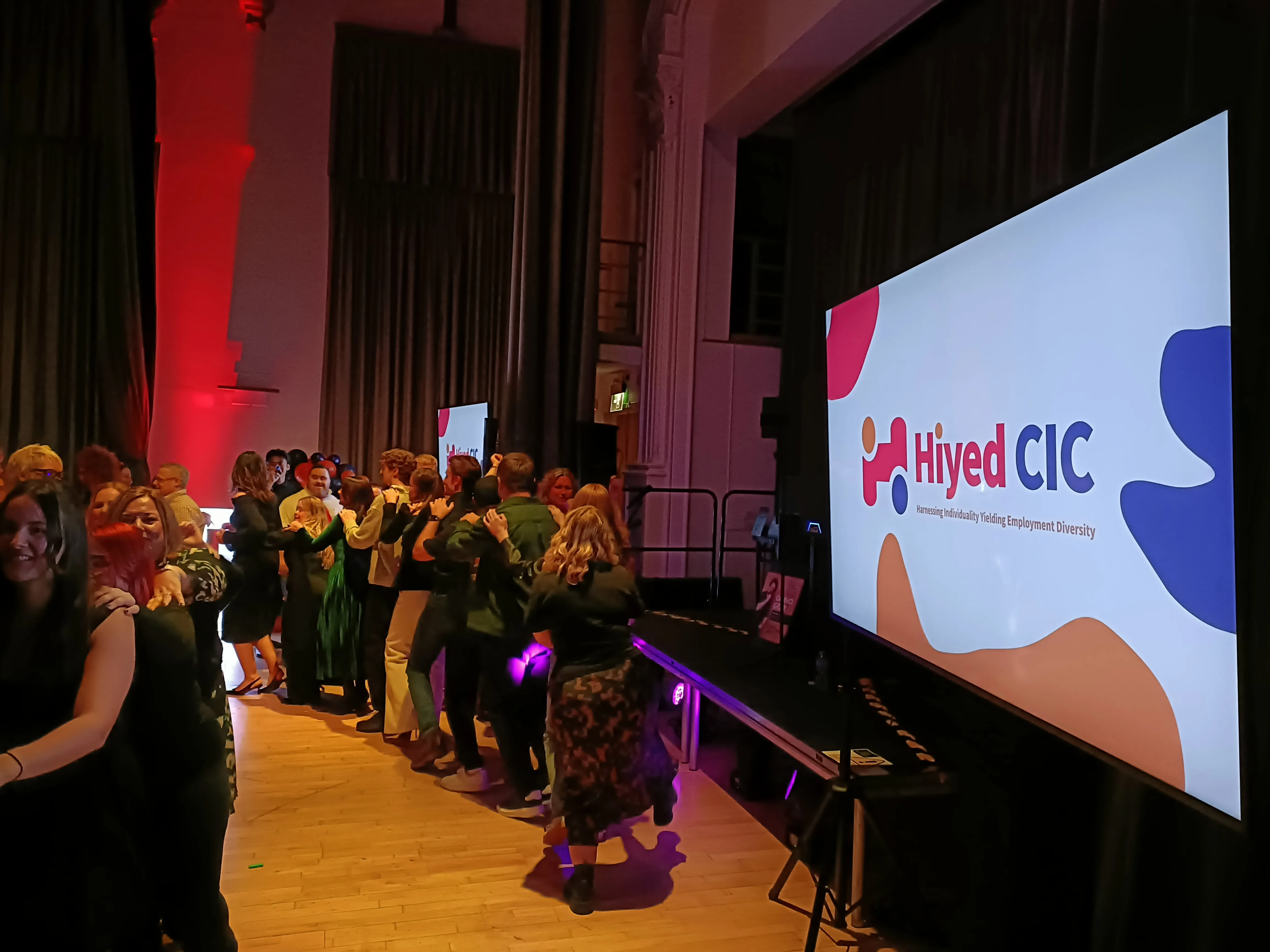 Guests on the dance floor in front of the Hiyed CIC branded screen