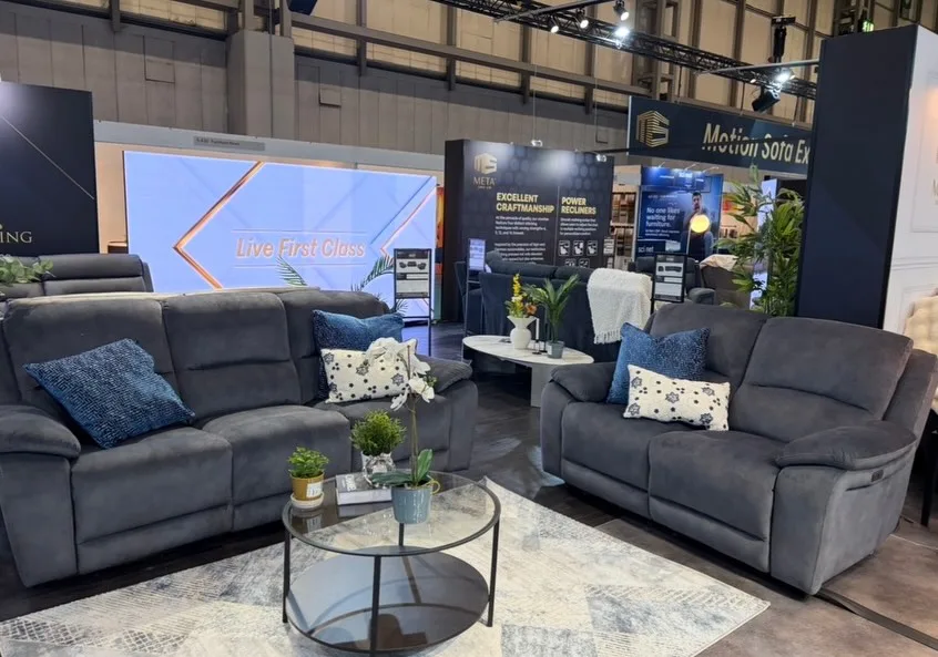 Dark fabric sofa display area within the exhibition stand