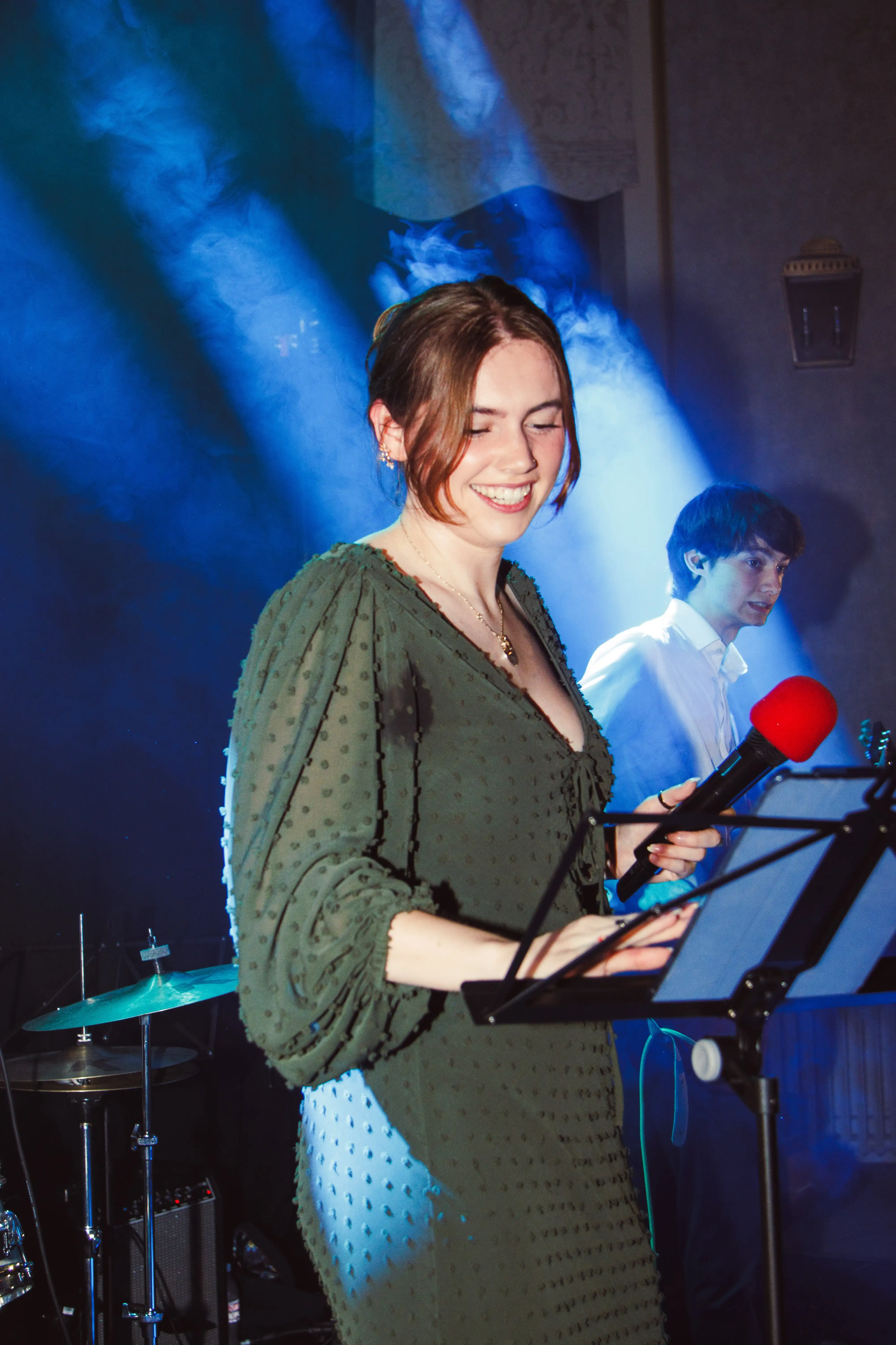 Vocalist performing under blue stage lighting